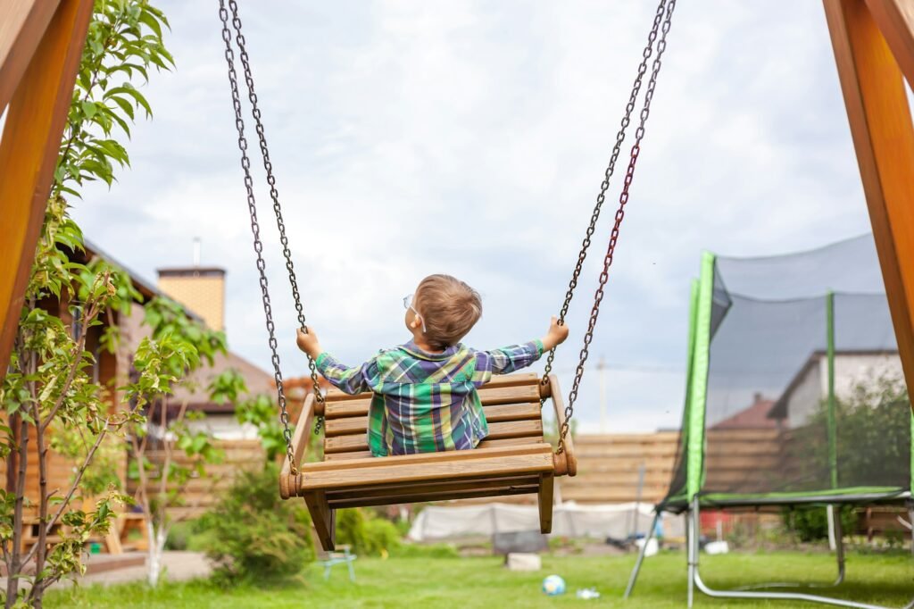 Child swinging on swing in the backyard