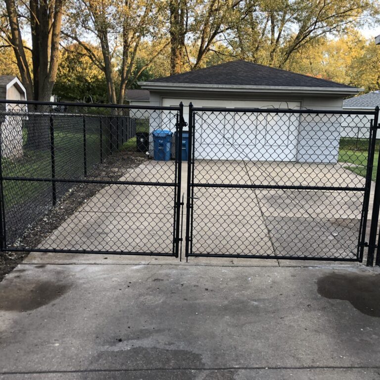 A black chain link fence in front of a house.