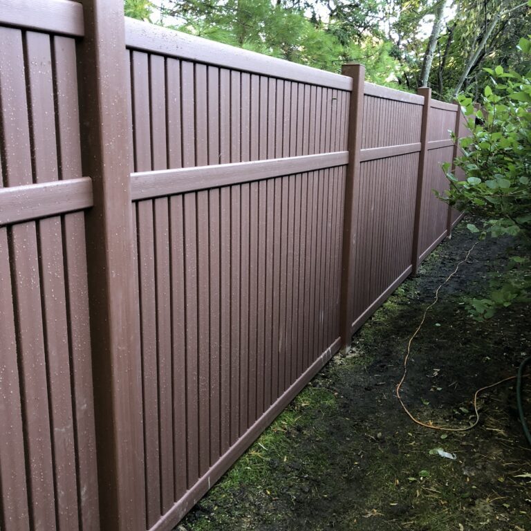 A brown wooden fence in a backyard.