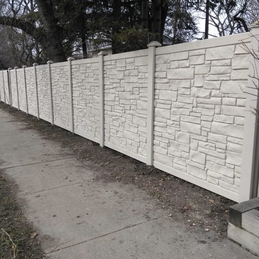 A white fence with white stones on it.