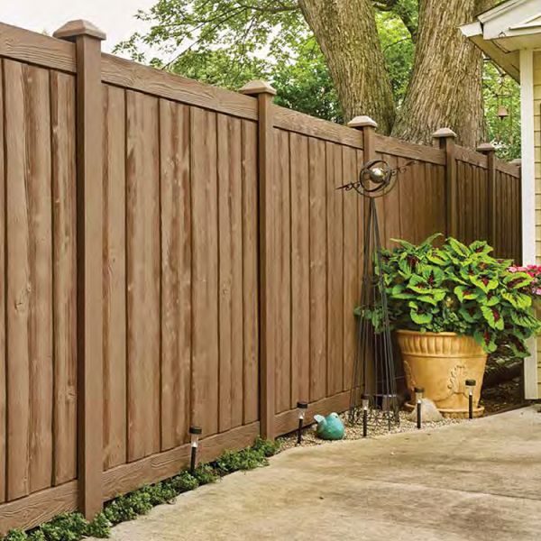 A backyard with a wooden fence and potted plants.